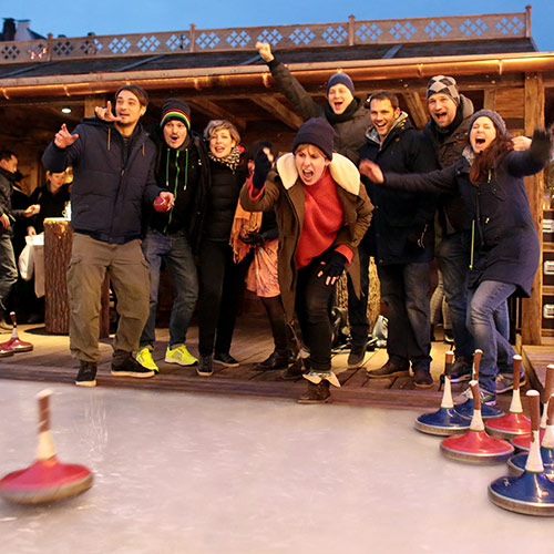 Spielspaß im Team beim Eisstockschießen auf dem Weihnachtsmarkt